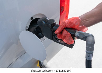 Mans Hand Wearing Glove While Pumping Gas During The COVID-19 Pandemic. 