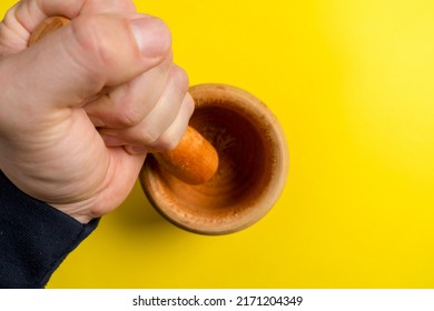 Man's Hand With A Wooden Kitchen Mortar Prepared To Make A Sauce.