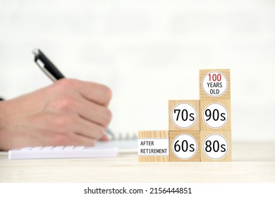 Man's hand writing on notebook　and wooden blocks with various aging word - Shutterstock ID 2156444851