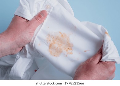 Man's Handing Hold Clothes With A Stain From Tomato Sauce. Top View