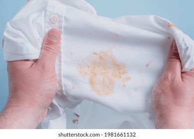 Man's Handing Hold Clothes With A Stain From Tomato Sauce. Top View