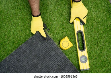 Man's Hands With The Artificial Grass Roll And Tools