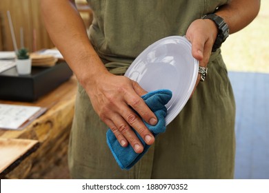 man's hands drying the dish in the resort party room, wipe it off with a dish towel                        - Powered by Shutterstock