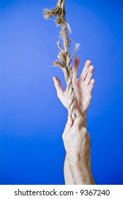 A Man's Hands Grasping Or Climbing Up A Frayed Rope Portraying A Very Precarious Situation.