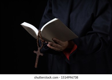 Man's Hands Holding Bible And Rosary During Prayer - Sepia Toned On Black Background