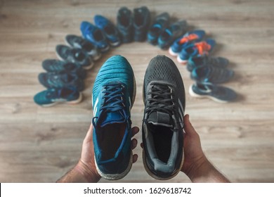 Man's hands holding different running shoes. - Powered by Shutterstock