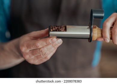 Man's Hands Holding Freshly Roasted Aromatic Coffee Beans Standing On Small Manufacturing