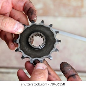 Man's hands holding a motocycle sprocket - Powered by Shutterstock