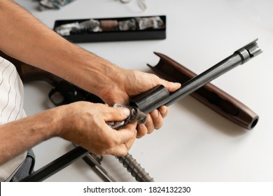 Man's Hands Holding Rifle Parts Details And Cleaning The Gun