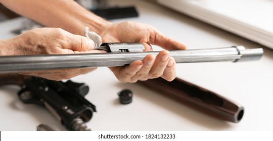 Man's Hands Holding Rifle Parts Details And Cleaning The Gun