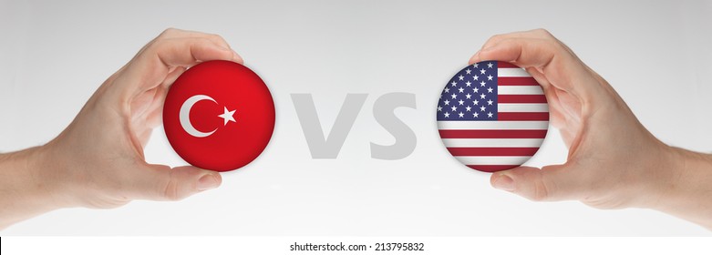 Man's Hands Holding Styrofoam Balls With Turkey And USA Flag Against The White Background.