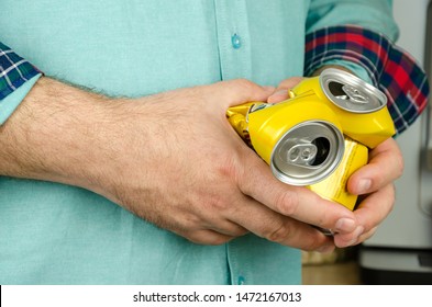 Man's Hands Holding Two Empty Crumpled Beer Cans