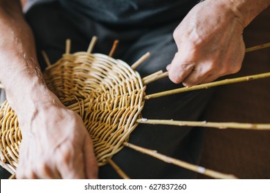 Man's hands making a wicker basket