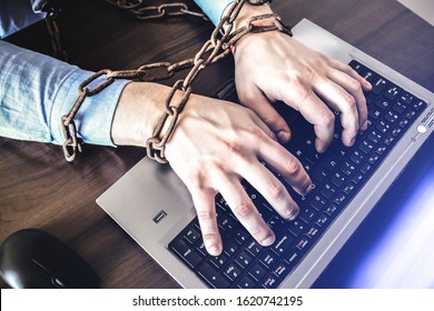 Man's hands in old rusty chains. In the trap of office work. Routine job. Manager near the laptop. - Shutterstock ID 1620742195