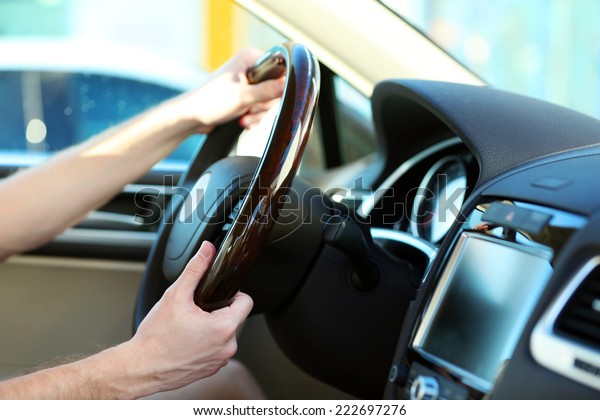 Man\'s hands on a steering\
wheel