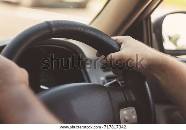 man\'s hands\
on the steering wheel retro toning\
car.