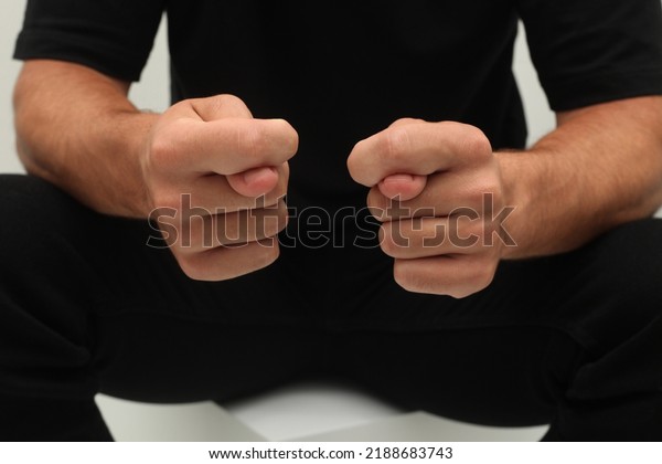 Man\'s hands shows the fig isolated on white\
background. A man in black shows a negative obscene gesture with\
his hands. Negative gesture\
concept.