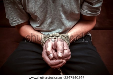 Man's hands tied with a rope.Personal violence concept.Dark tone.