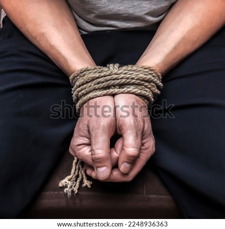 Man's hands tied with a rope.Personal violence concept.Dark tone.