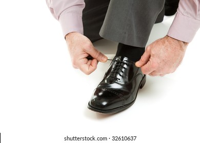 Man's hands tying shoelace of his new oxford shoes.  Isolated on white. - Powered by Shutterstock