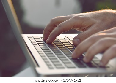 Man's hands typing on laptop keyboard. 