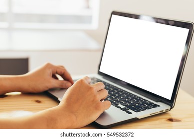 Man's Hands Using Laptop With Blank Screen On Desk In Home