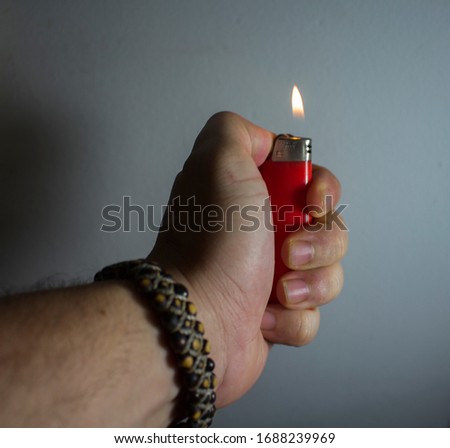 man's left hand with a lighter