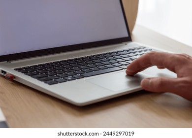 man's scrolling on laptop touch bar, close up black keyboard , silver modern laptop, blank white screen, close up