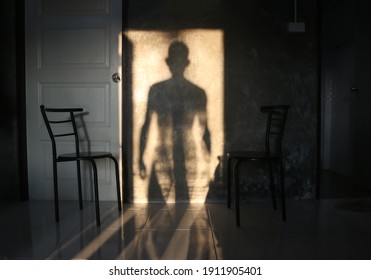 
The man's shadow stood in the door on the wall. - Powered by Shutterstock