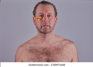 Mans Skin Care Image Where The Man Has A Collagen Under Eye Mask Applied,the Image Was Shot Close Up And On A Grey Background.