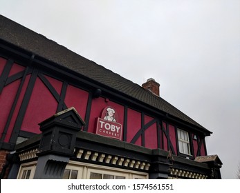 MANSFIELD, UK - NOVEMBER 24, ‎2019: Purple And White Sign And Exterior Of Toby Carvery Watermill,  The Traditional Home Of The Roast Dinner, Against A Grey, Cloudy Autumn Sky At Sutton-in-Ashfield