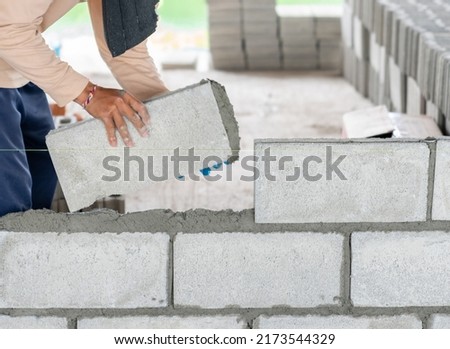 Mansonry install concrete brick for wall of building in construction site.
