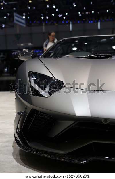 Mansory custom car version of Lamborghini Urus in\
Geneva International Motor Show (GIMS) 2019. Beautiful matte grey\
colored luxury car with a powerful motor and unique style. Front of\
the car.