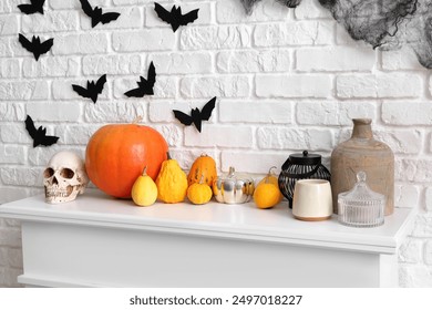 Mantelpiece with Halloween decor and paper bats on white brick wall in room - Powered by Shutterstock