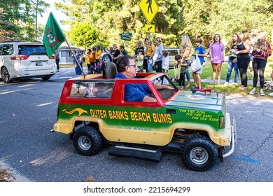 Manteo, North Carolina USA-10 15 2022: A Man Drives A Tiny Green Car In The Manteo High School Homecoming Parade.