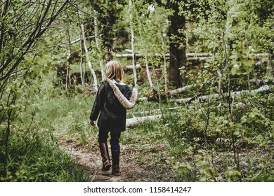 Manti, UT / United States - June 7, 2018: Young Little Girl Walking Through Woods In Fur Coat 