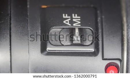 The Manual and Auto Focus button on a macro shot of the black camera