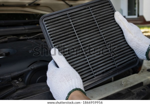 Manual car air filter replacement to maintain\
engine performance.Air filter is clogged. Causing incomplete\
combustion in the engine\
compartment