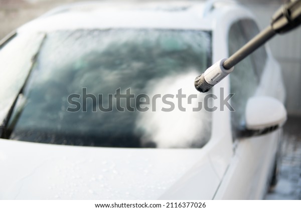 Manual car wash with white soap, foam on\
the body. Manual car wash outside. Close up. Cleaning Car Using\
Washing with soap. High Pressure\
Water.