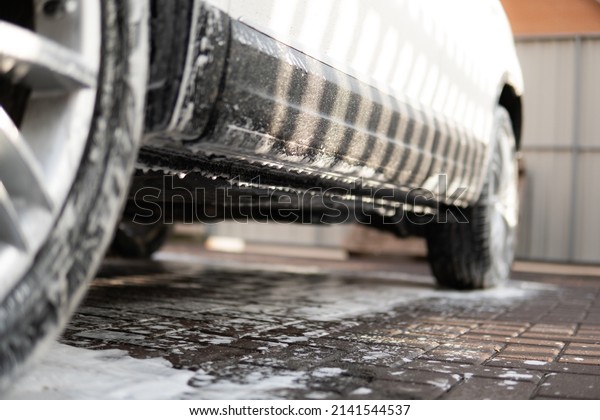 Manual car wash with white soap, foam on the body.\
Washing with soap. Close up. Manual car wash outside. Cleaning Car\
Using High Pressure\
Water.