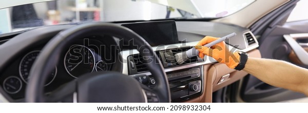 Manual cleaning of car\
interior with brush for hard-to-reach places in dashboard. Car\
cleaning concept