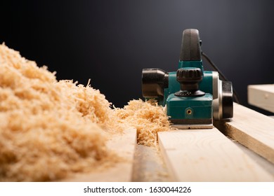 Manual electric plane on raw tree log. Woodwork. Manufacture of wood products. Carpentry workshop - Powered by Shutterstock