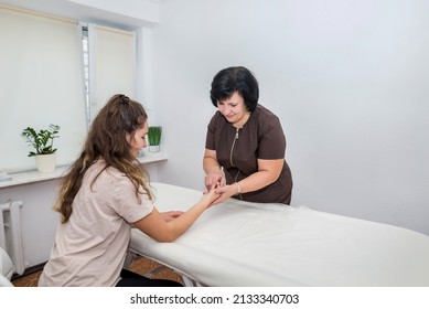 Manual Massage. A Female Therapist Presses Specific Points On The Patient's Wrist. Professional Acupressure Treatments For Health And Wellness