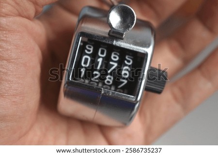 manual number counter in the palm of the hand