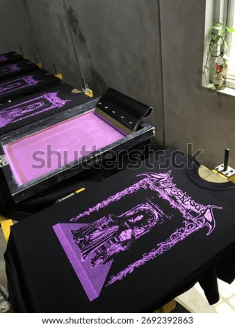 Manual screen printing process using plastisol ink on cotton fabric, perfect for themes of creative industry, fashion, printing, and handmade apparel.