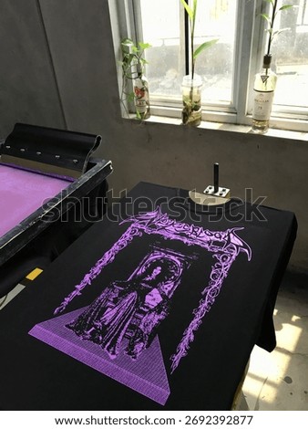 Manual screen printing process using plastisol ink on cotton fabric, perfect for themes of creative industry, fashion, printing, and handmade apparel.