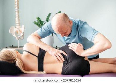 Manual therapist fixing sacroiliac joint pain with his hands, osteopath releasing trigger points and correcting joint alignment