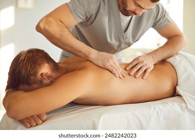 Manual therapy, body relaxing back massage in clinic, cosmetology spa centre, massaging male patient. Male osteopathic manual practitioner, reflexology or medical technique to restore health, muscles  - Powered by Shutterstock