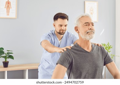 Manual therapy doctor, rehabilitation, male nurse, physical therapist fixing senior man back, shoulders in medical clinic room. Patient getting massage, reduce disability body health, sport, wellness - Powered by Shutterstock