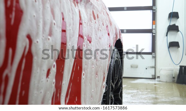 Manual wash for perfect\
clean car. Cleaning car using high pressure water, Man cleaning\
vehicle with high pressure water spray or jet. Car wash details,\
Close up concept. 